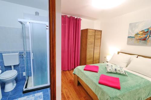 a bedroom with a bed and a glass shower at Vila Mila in Vela Luka