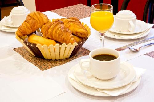 a table with a basket of pastries and a cup of coffee at Hipotel Belgrand Edith Piaf in Paris