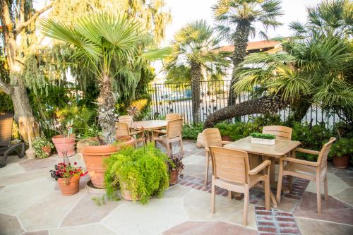a patio with tables and chairs and palm trees at Adelaide Inn in Paso Robles