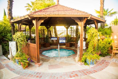 a wooden gazebo with a swimming pool at Adelaide Inn in Paso Robles