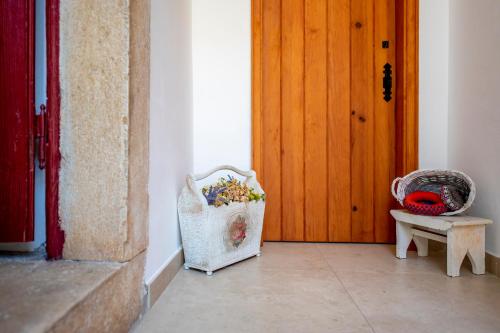 a room with a door and a basket of flowers at Lagar do Sapateiro in Fontes