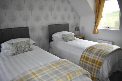 two beds sitting next to each other in a bedroom at Monturpie Guest House in Kirkton of Largo