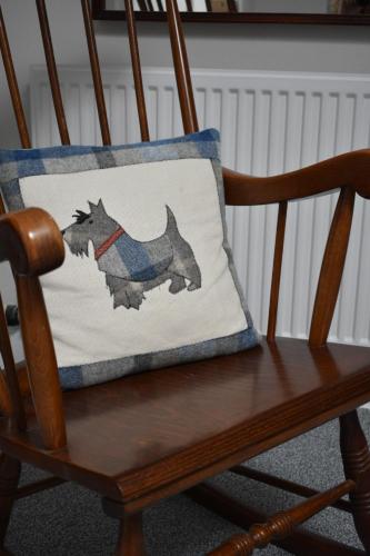 a pillow with a dog on it sitting on a chair at Monturpie Guest House in Kirkton of Largo