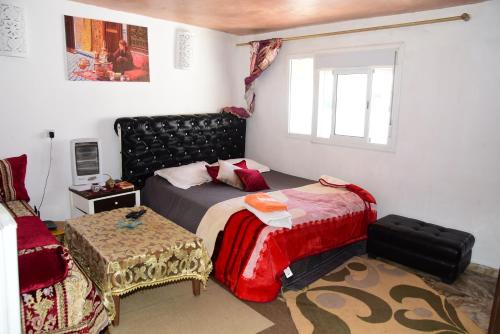 - une chambre avec un lit, une chaise et une fenêtre dans l'établissement Chambre Perle Amine, à Rabat