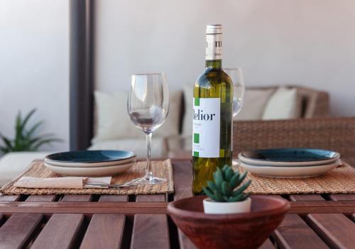 a bottle of wine and a wine glass on a table at Apartamentos Plaza Mayor 35 in Cáceres