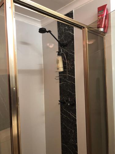 baño con ducha con una luz en la pared en The Blacklighters Opal Retreat-Undergound, en Coober Pedy