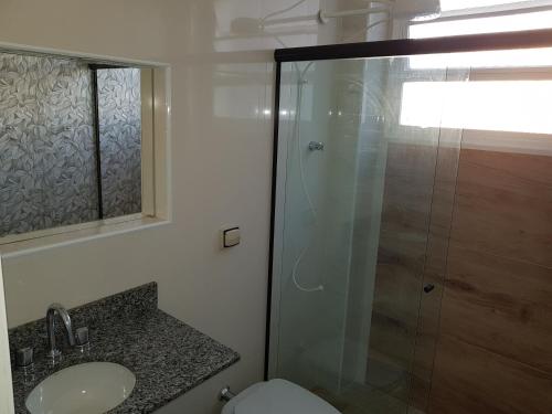 a bathroom with a shower and a sink and a toilet at NAUTILUS SEAVIEW BAY-SV/SP in São Vicente