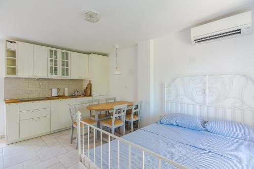 ein Schlafzimmer mit einem Bett und einem Tisch sowie eine Küche in der Unterkunft Ribar 1 in Njivice