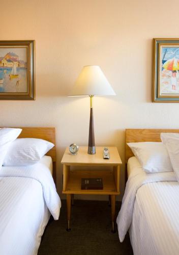a hotel room with two beds and a table with a lamp at Sunset Motel Moriarty in Moriarty