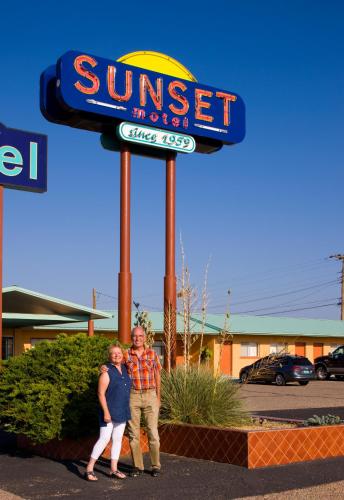 a man and woman standing in front of a sunset motel sign at Sunset Motel Moriarty in Moriarty