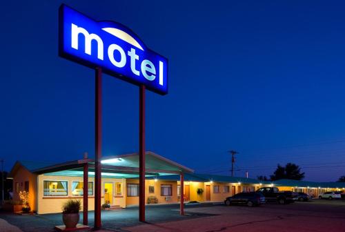 a neon motel sign in front of a motel at Sunset Motel Moriarty in Moriarty