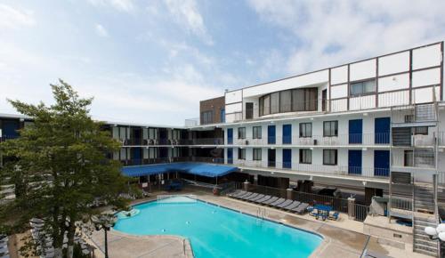 a hotel with a swimming pool in front of a building at Brittany Motel in Wildwood