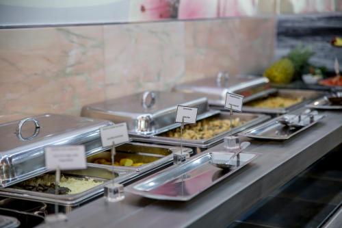 a buffet line with many trays of food at Hotel Maritur - Adults Only in Albufeira