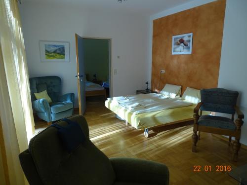 a bedroom with a bed and a couch and a chair at Gartenapartment in Zell am See