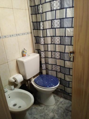 y baño con aseo azul y lavamanos. en Posada Capital en Neuquén