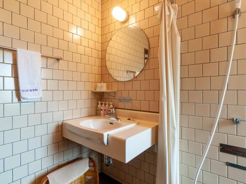 a bathroom with a sink and a mirror at Kikuchi Grand Hotel in Kikuchi