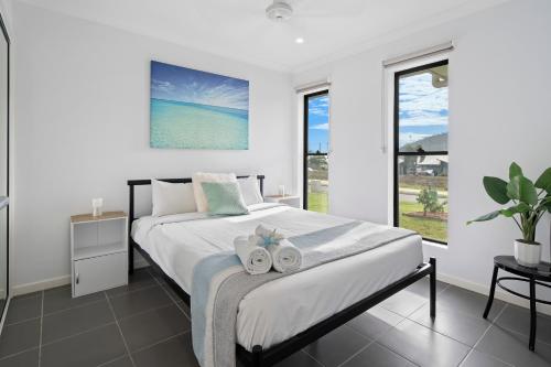 a bedroom with a bed with two towels on it at Whitsundays Paradise by the Port in Airlie Beach