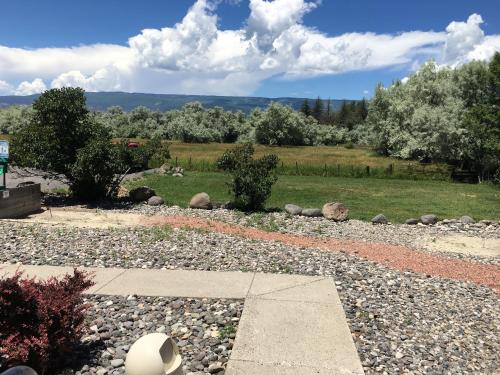 a garden with rocks and trees and a field at Stay Wise Inn Cedaredge in Cedaredge