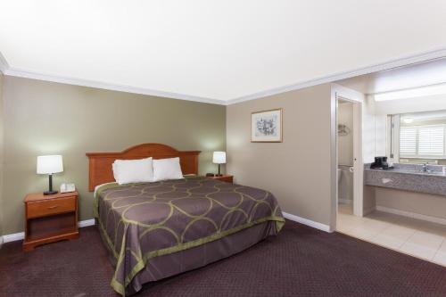 Un pat sau paturi într-o cameră la Super 8 by Wyndham Torrance LAX Airport Area