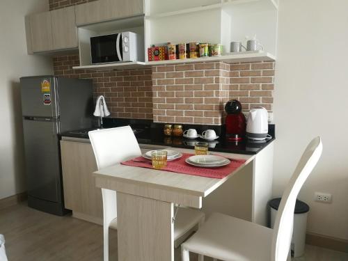 a small kitchen with a table and a microwave at Diamant Modern Room Condominium Resort in Chiang Mai