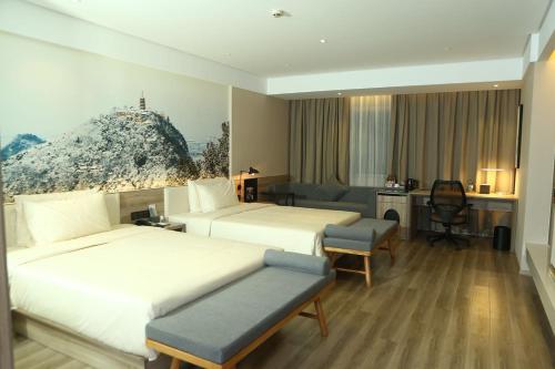 a hotel room with two beds and a desk at Atour Hotel (Nantong Zhongcheng) in Nantong