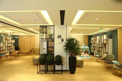 a lobby with a library with tables and chairs at Atour Hotel (Nantong Zhongcheng) in Nantong