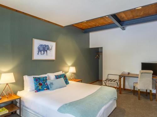 a bedroom with a bed and a table and a desk at The Narrows Landing Hotel in Hamilton