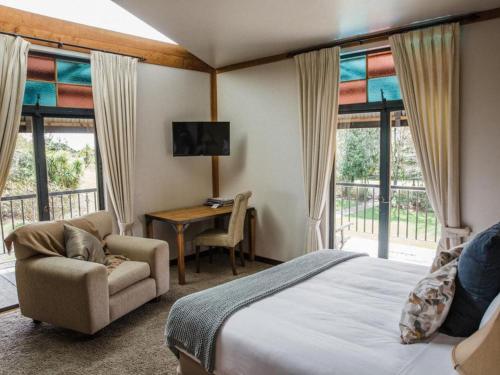a bedroom with a bed and a chair and a desk at The Narrows Landing Hotel in Hamilton
