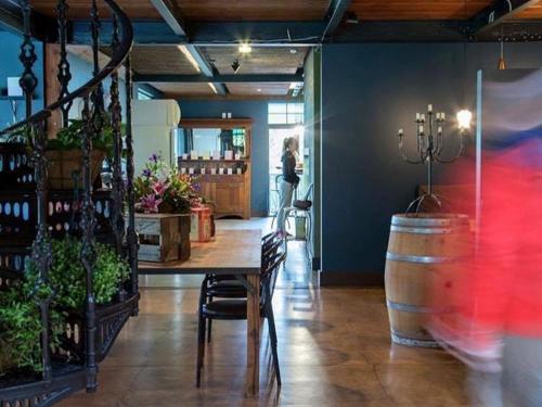 a woman standing in a room with a table and a barrel at The Narrows Landing Hotel in Hamilton