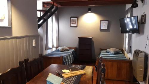 a dining room with two beds and a table at Cabañas Cerros del Sol in Merlo