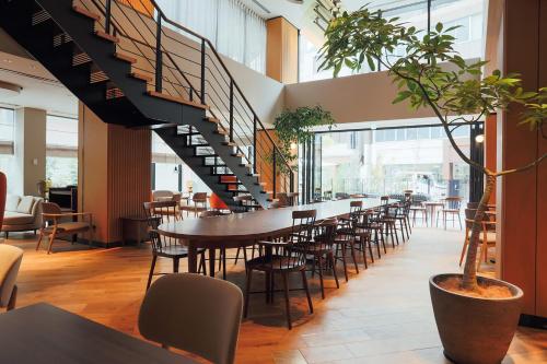 a dining room with a table and chairs and a staircase at NOHGA HOTEL UENO TOKYO in Tokyo
