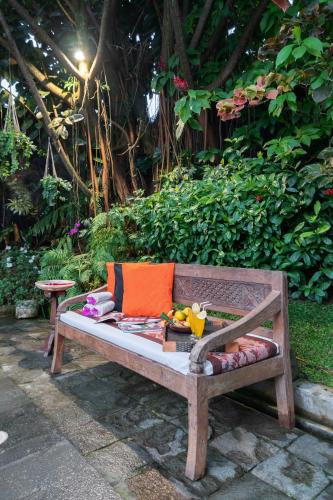 a wooden bench sitting in front of a garden at Villa Mulyono in Batu