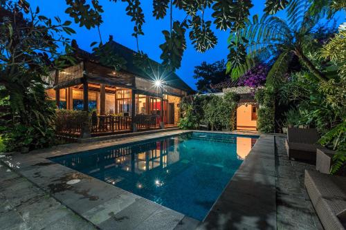 an exterior view of a house with a swimming pool at Villa Mulyono in Batu