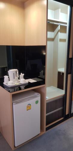 a small kitchen with a white refrigerator in a room at Ariston Hotel Bangkok in Bangkok