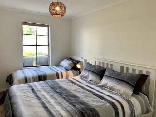 1 dormitorio con 2 camas y ventana en Berds Nest en Emu Bay