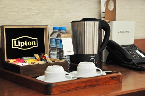 a wooden tray with a jug and cups on a desk at Mövenpick Hotel Izmir in Izmir