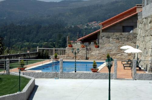 a swimming pool in front of a house at Hotel Liñares in Poio