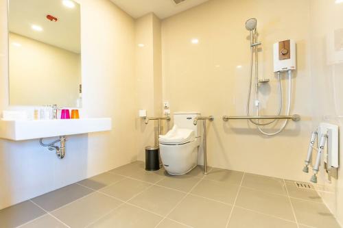 a bathroom with a toilet and a shower in it at Centre Point Prime Hotel Pattaya in Pattaya North