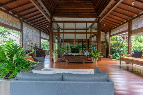 a large living room with a couch and a tv at Villa Mulyono in Batu