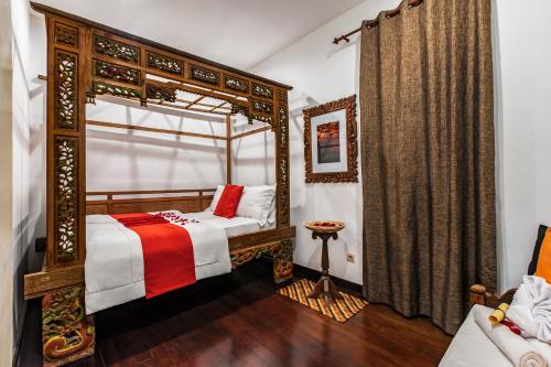 a bedroom with a canopy bed and a couch at Villa Mulyono 2 in Batu