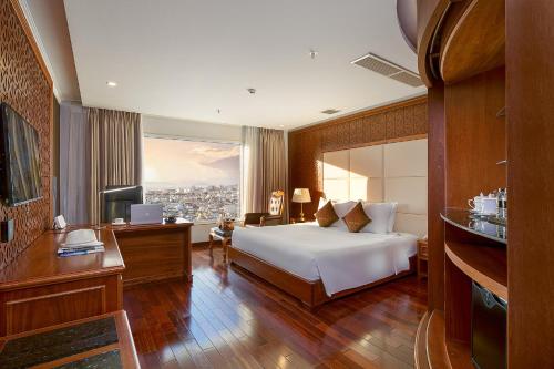 峴港的住宿－Samdi Da Nang Airport Hotel，一间卧室配有一张床、一张书桌和一台电视