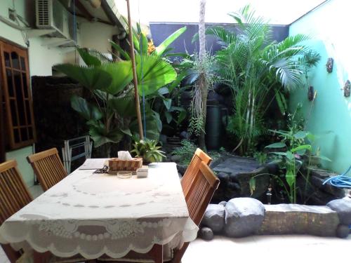 a table and chairs in a patio with a garden at The Homey Rooms and Tours in Yogyakarta