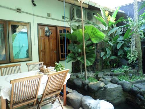 a patio with a table and chairs and a garden at The Homey Rooms and Tours in Yogyakarta