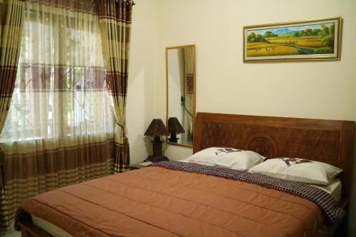 a bedroom with a bed and a window at The Homey Rooms and Tours in Yogyakarta