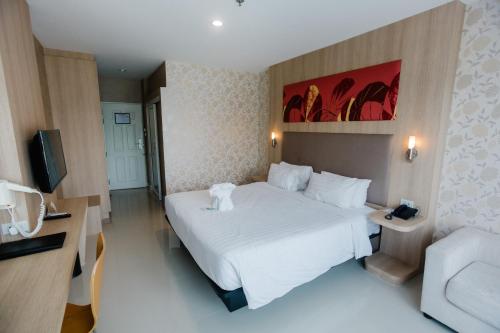 a hotel room with a large white bed and a couch at Best Western Royal Buriram in Buriram