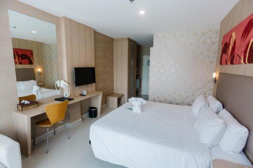 a hotel room with a white bed and a desk at Best Western Royal Buriram in Buriram