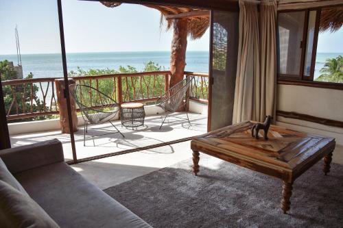 a living room with a couch and chairs on a balcony at Spirit Holbox in Holbox Island