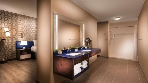 a bathroom with a sink and a mirror at GLo Best Western Nashville Airport in Nashville
