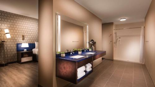 a bathroom with a sink and a mirror at GLō Best Western Nashville in Nashville