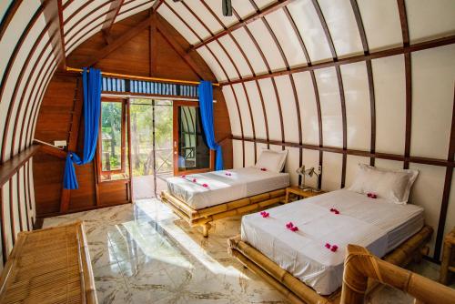 a room with two beds in a room at The Papalagi Resort in Gili Gede